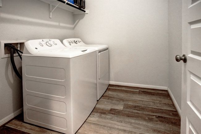 Laundry room with baseboards, wood finished floors, laundry area, and independent washer and dryer | Image 30