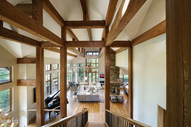 Spacious Great Room Framed by Floor-to-Ceiling Windows and a Striking Three-Sided Stone Fireplace. | Image 34