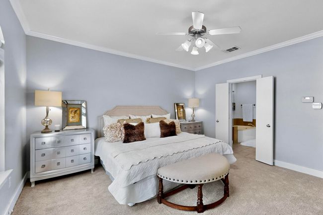 Bedroom with carpet floors, crown molding, ensuite bath, and ceiling​​‌​​​​‌​​‌‌​‌‌​​​‌‌​​‌‌​‌​​​​​‌ fan | Image 26