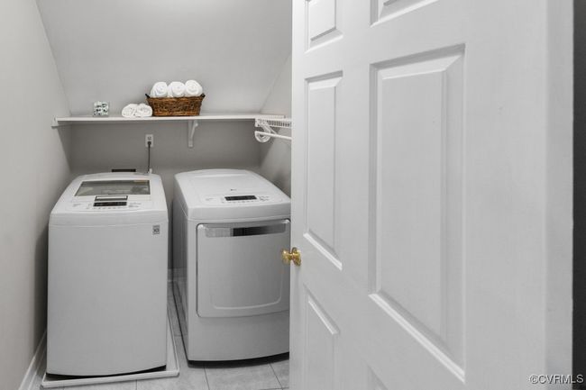 Laundry room featuring washer and dryer and light tile patterned flooring | Image 39