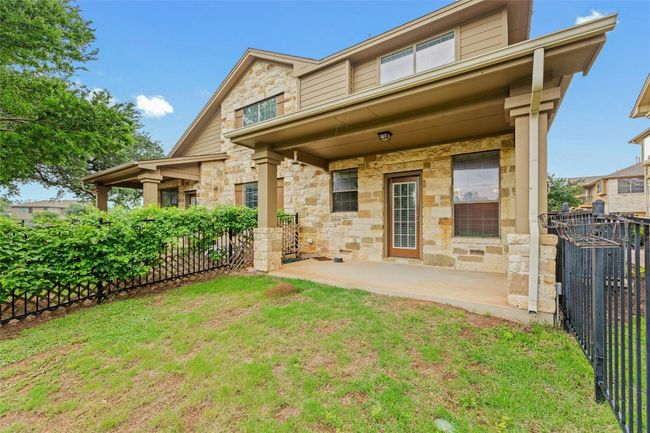 Rear view of house with stone siding and a patio area | Image 28