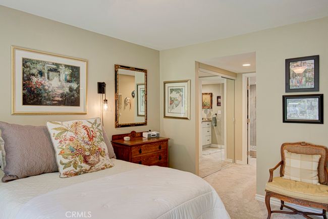 Another view of the primary bedroom suite. Closet with mirrored doors and entry to the bathroom can be seen in the background. | Image 21