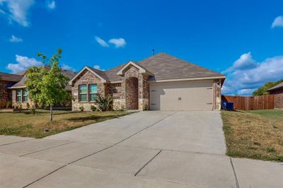 Single story home with cooling unit, a front lawn, and a garage | Image 1