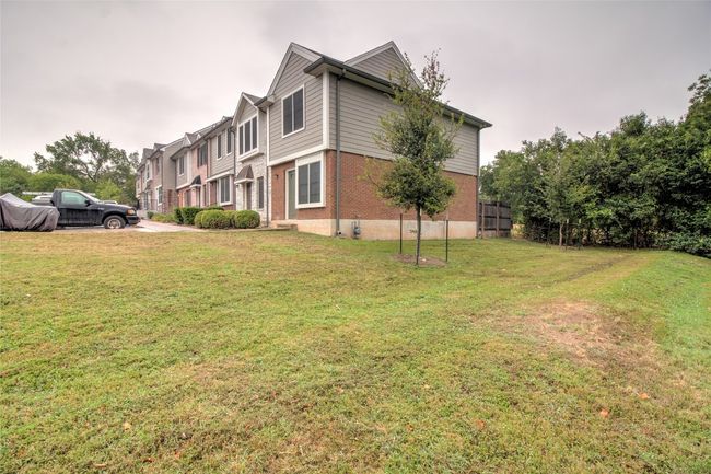 View of home's exterior with brick siding and a lawn | Image 6