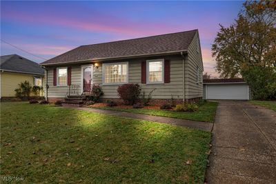 View of front of property featuring a garage, an outbuilding, and a lawn | Image 2