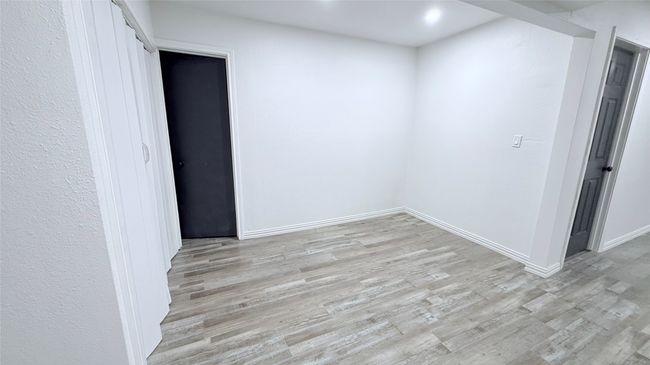 Empty room with light wood-style flooring, baseboards, and recessed lighting | Image 8