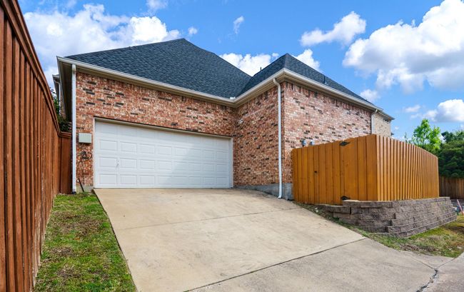 2car attached garage, concrete driveway, brick siding, and a shingled roof | Image 24