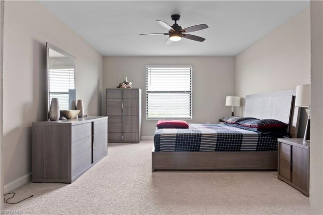 Bedroom featuring baseboards, a ceiling fan, and light carpet | Image 19