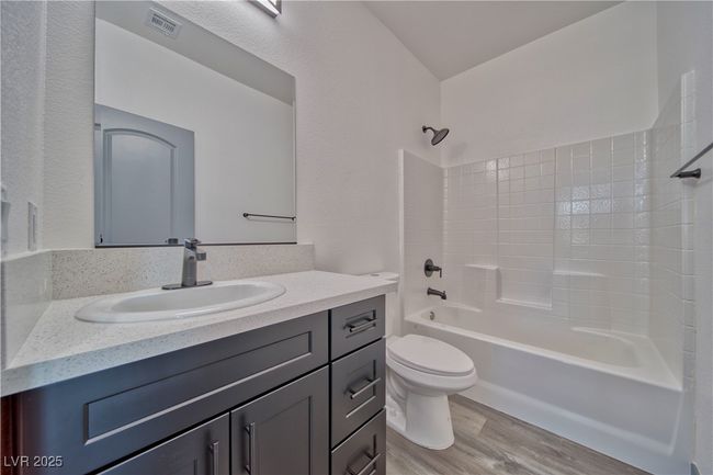 Stylish guest bathroom featuring a full-size tub and custom cabinets, offering both function and modern finishes. **These are model photos, light fixtures subject to change.** | Image 9