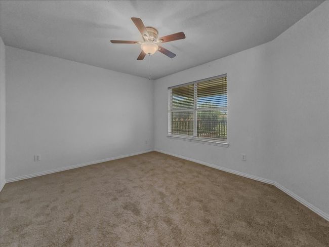 Carpeted empty room featuring ceiling fan and baseboards | Image 23