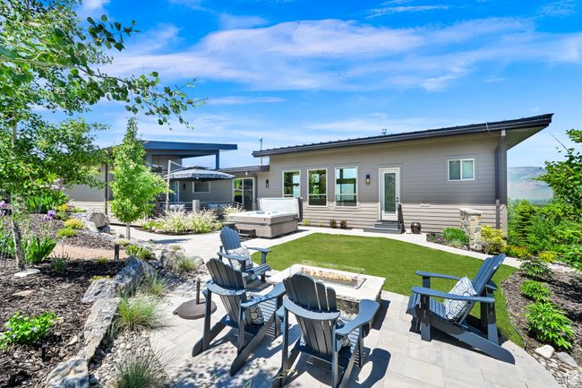 Back of property featuring a hot tub, an outdoor fire pit, entry steps, and a patio area | Image 66