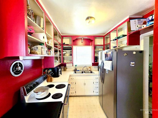 Kitchen featuring open shelves, stainless steel fridge, electric range, and light flooring | Image 7