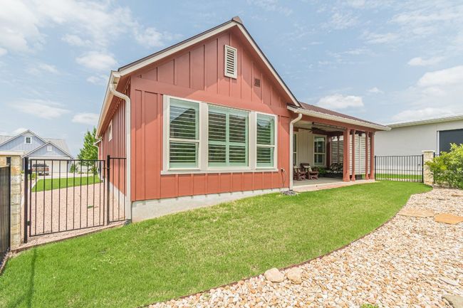 Rear view of property with board and batten siding, a patio area, ceiling fan, and a gate | Image 33