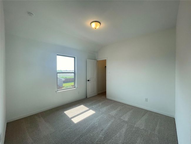Unfurnished room with carpet, a smoke detector, and lofted ceiling | Image 19