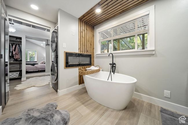 Bathroom featuring baseboards, a soaking tub, wood finished floors, and recessed lighting | Image 17