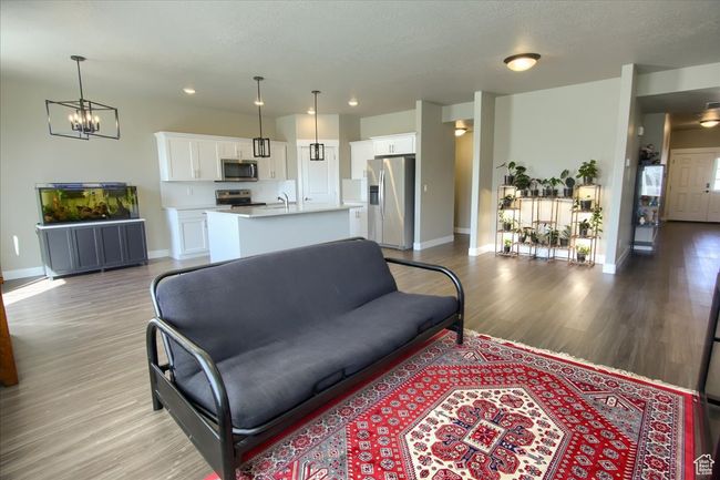 Living area featuring recessed lighting, a notable chandelier, light wood-style floors, and baseboards | Image 4
