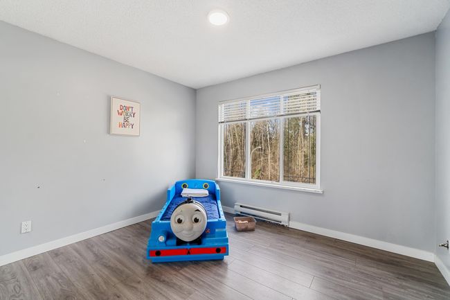 Recreation room with a baseboard radiator, wood finished floors, and baseboards | Image 18