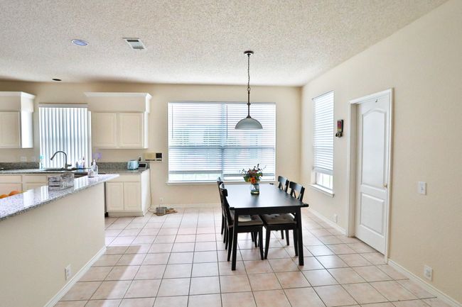 Dining area featuring a textured ceiling and light tile patterned floors | Image 4