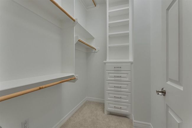 The second primary bedroom closet is also thoughtfully designed with built-in shelving and drawers, along with ample hanging space to accommodate a variety of storage needs. | Image 28