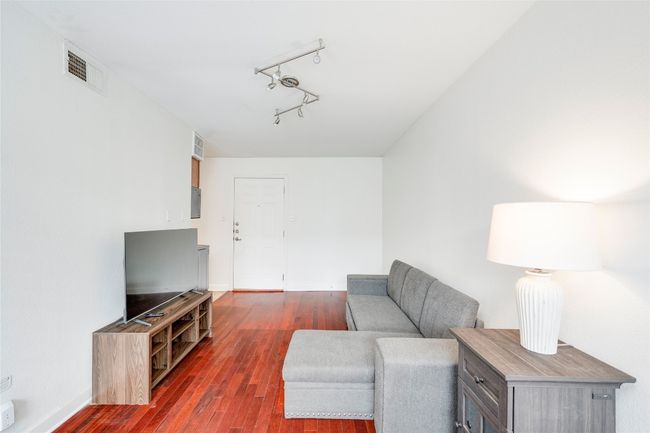 Living room with dark wood-style flooring, baseboards, and track lighting | Image 18