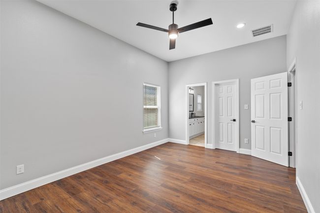 Unfurnished bedroom with ceiling fan, a towering ceiling, with an ensuite. | Image 19