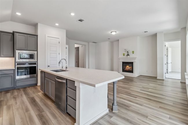 Kitchen featuring appliances with stainless steel finishes, gray cabinetry, light wood-style flooring, recessed lighting, and light countertops | Image 14