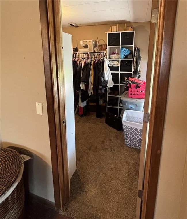 Master bedroom walk-in closet featuring shelving for extra storage capacity | Image 22