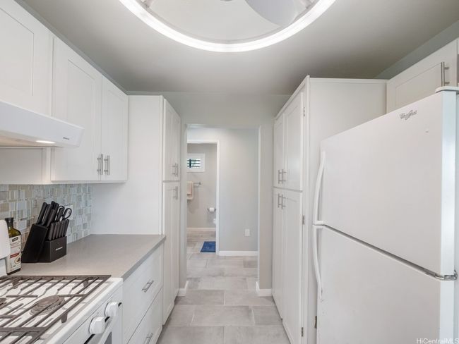 Stacked washer and dryer to the right inside cabinet | Image 12