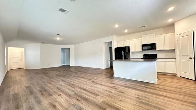 Kitchen with visible vents, white cabinets, and black appliances | Image 17
