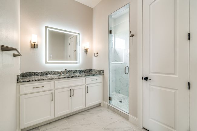 Bathroom with a shower with shower door, tile flooring, and vanity | Image 16