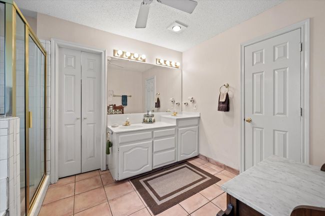 Primary bathroom offers large jetted soaking tub and separate shower, along with plenty of vanity space and cabinetry for organizing your toiletries. | Image 31
