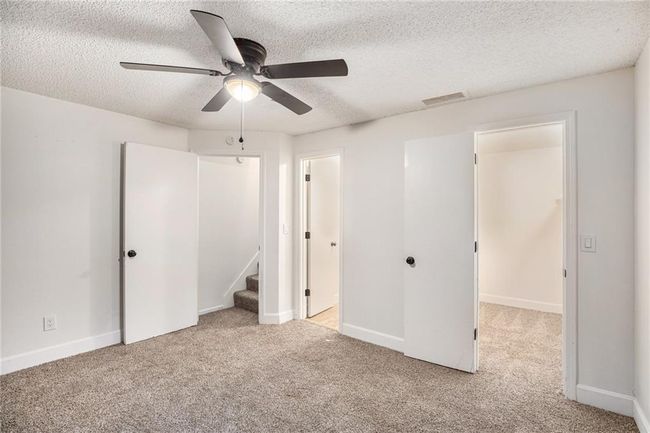 Unfurnished bedroom with carpet flooring, a textured ceiling, baseboards, and a ceiling fan | Image 15