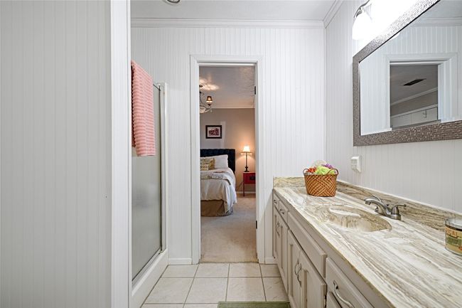 Bathroom with tile patterned flooring, vanity, an enclosed shower, and crown molding | Image 30