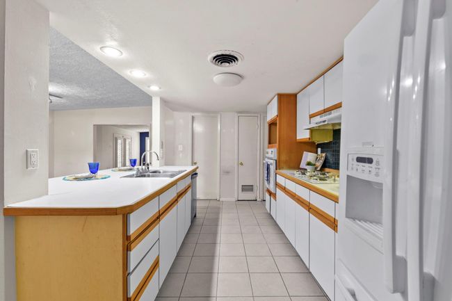 This kitchen features a spacious walk-in pantry and includes a refrigerator, making it move-in ready. | Image 11