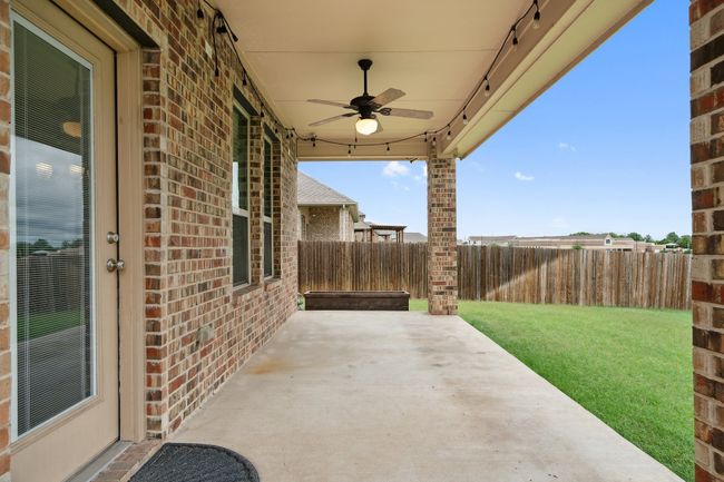 Fenced backyard featuring a ceiling fan and a patio area | Image 27