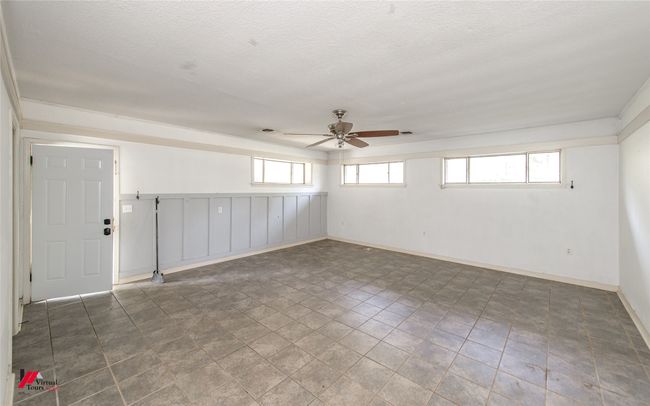 Empty room featuring baseboards, a textured ceiling, and ceiling fan | Image 19