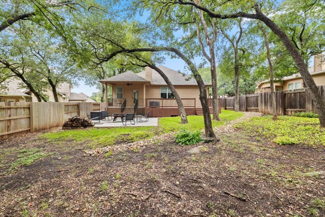 Rear view of property featuring a fenced backyard, a patio, a wooden deck, and a shingled roof | Image 36