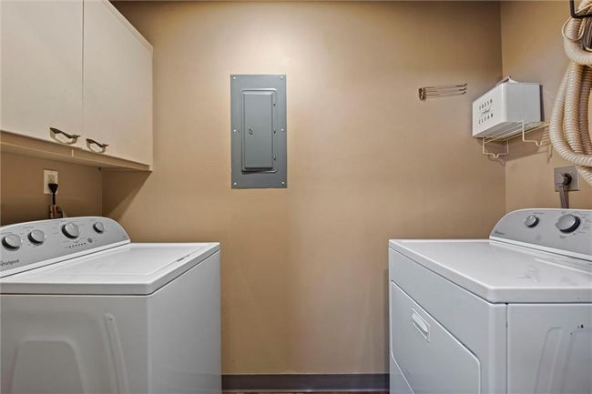 Washroom with electric panel, cabinet space, and washing machine and dryer | Image 18