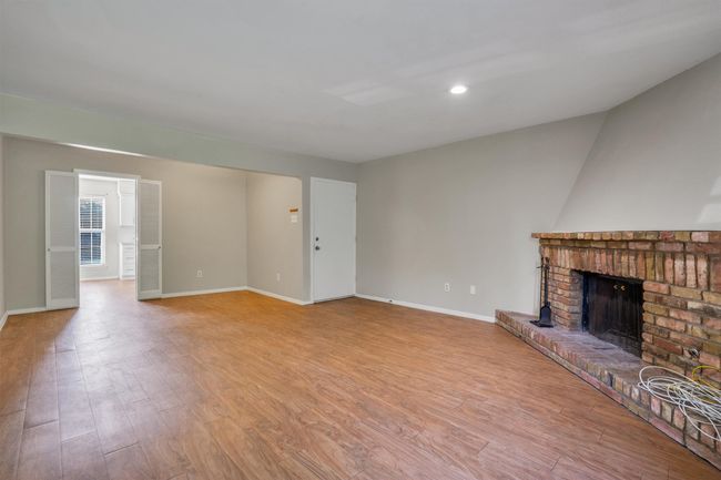 Unfurnished living room featuring a fireplace, light finished floors, and recessed lighting | Image 5