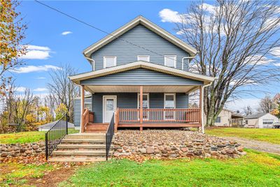 View of front of property with freshly stained covered porch, custom handrails and masonry. | Image 1