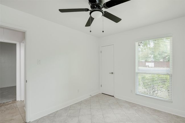 Empty room with attic access, baseboards, and ceiling fan | Image 17