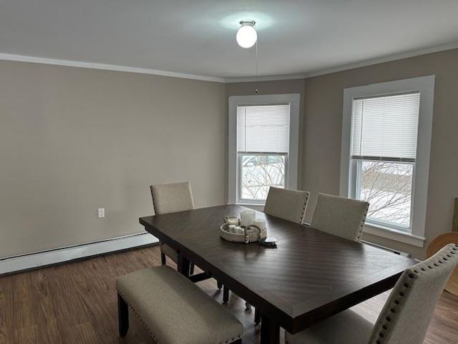 Dining room with hardwood / wood-style floors, crown molding, and a baseboard radiator | Image 15