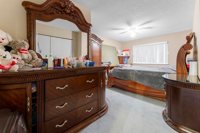 Carpeted bedroom with ceiling fan and a textured ceiling | Image 17