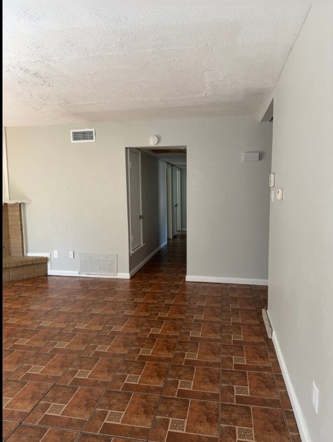 Spare room with a textured ceiling and brick patterned floors | Image 6