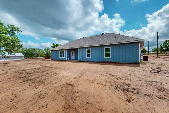 Back of house with roof with shingles and board and batten siding | Image 4