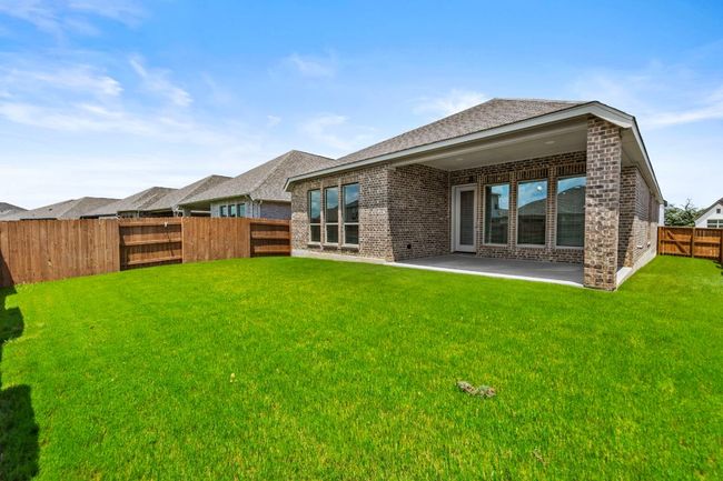 Back of property with brick siding, a fenced backyard, roof with shingles, and a patio area | Image 24