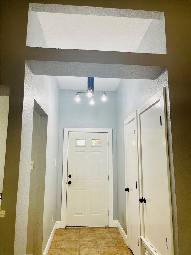 Doorway to outside with a textured ceiling and light tile patterned floors | Image 9