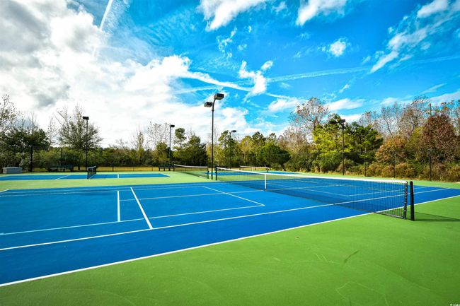 View of tennis court with community basketball court and view of wooded area | Image 5