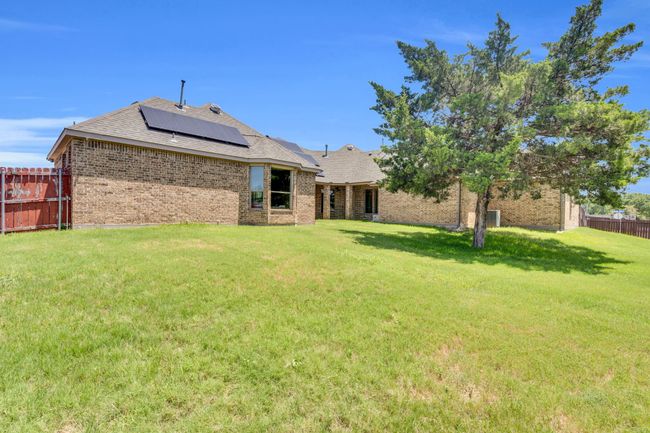 Back of property with brick siding, a shingled roof, and solar panels | Image 36