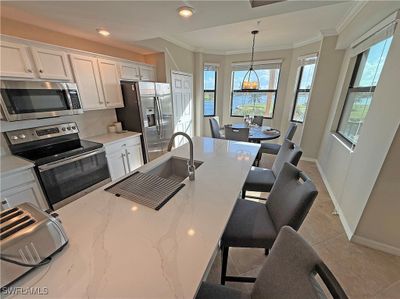 Kitchen with white cabinetry, Quartz countertops, stainless steel appliances, and a healthy amount of sunlight | Image 3